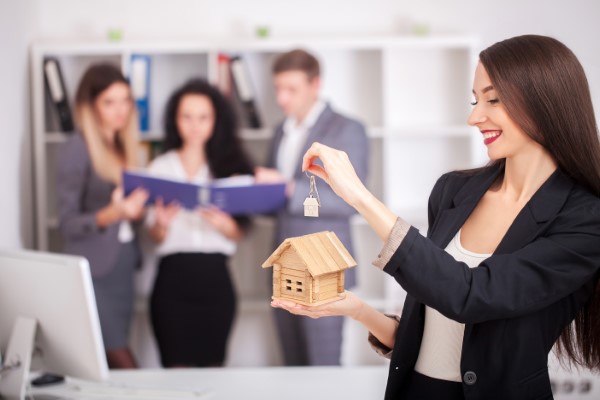 Fotografía de asesora inmobiliaria que se encuentra mostrando inmuebles en venta CDMX a algunos futuros clientes potenciales.